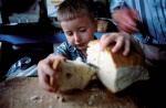 Greece,West Thrace,Rodope mountain.Pomakochoria (Greek Muslim minority. Litlle boy takes a piece of bread.
 © Maro Kouri