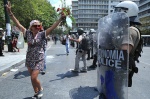 48 hours general strike and demonstations against the Memorandum. Thousands of demonstrators join the Indignant Citizens///Woman with flowers dances in front of the greek Riot Police
 © Maro Kouri