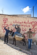 Young men in front of graffity, which referres to the revolution martyrs.

 © Maro Kouri
