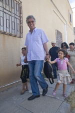 Hamma Hammami, with children walks in Redeyef, soutwest of Tunisia. Hamam Hammami is the leader of the (unauthorized during Ben Ali regime) Communist Party of Tunisian Workers PCOT  (Parti Communiste des Ouvriers de Tunisie), and director of the (ex-banned) newspaper El Badil (‘‘The Alternative‘‘). Hamma was hiding many times, and also many years he was brutal tortured and imprisoned after unfair trials. 
 © Maro Kouri