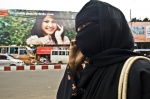 Chittagong, Banglasesh; Contrast between a woman dressed in nigab walking on the street and an advertisement-wallpaper showing a woman dressed in west style, talking also on the mobile phone
 © Maro Kouri