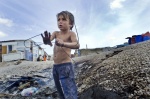 October 26, 2011- Botanikos, Athens Greece: Franco is a little boy who works all day and sometimes even during the night in the burnt junk yard where he collects scrap metal in order to sell it
 © Maro Kouri
