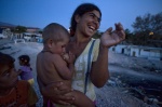 July 5, 2011-Botanikos, Athens, Greece: Roma woman with gold tooth laughs and breasfeeds her baby in the shanty town
 © Maro Kouri